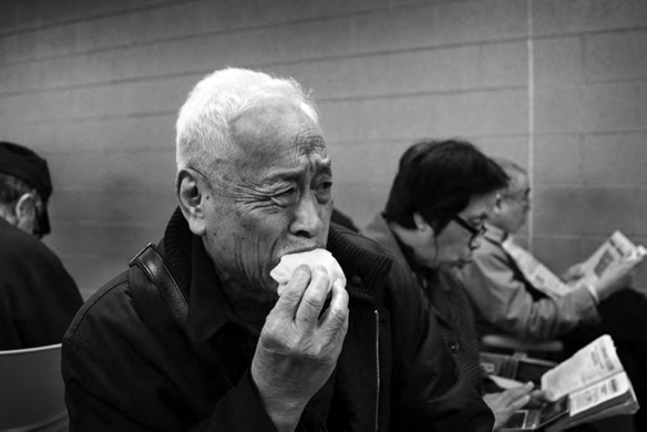 A Chinese elder eats a late meal inside the casino waiting room. Photo by Yeong-Ung Yang.
